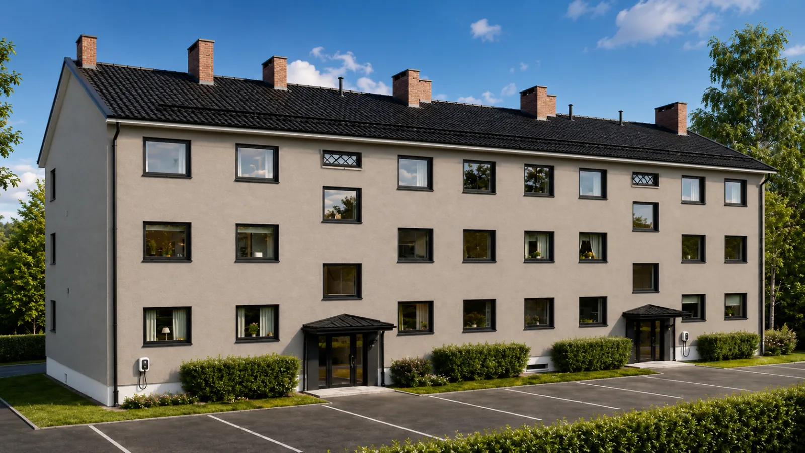 Boligbygg med lys fasade, mørkt tak og inngangspartier